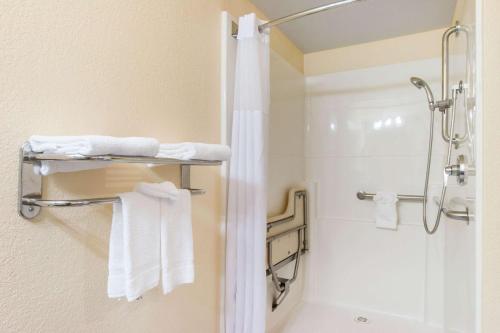 a bathroom with a shower and white towels at Quality Inn & Suites Redwood Coast in Crescent City