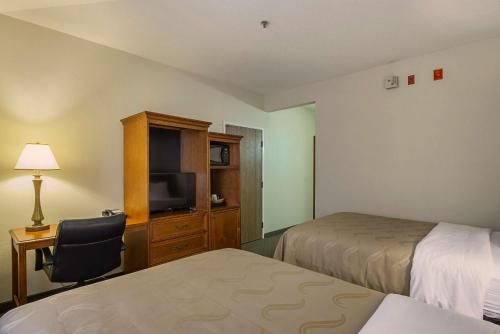 a hotel room with two beds and a television at Quality Inn Fresno Yosemite Airport in Fresno