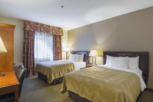 a hotel room with two beds and two lamps at Quality Inn Fresno Airport in Fresno