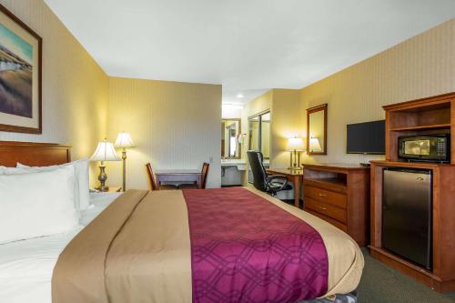 a hotel room with a large bed and a desk at Econo Lodge Inn & Suites Riverside - Corona in Riverside