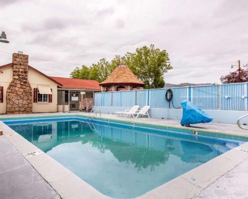 a swimming pool with a blue fence and a building at Jefferson Inn in Yreka