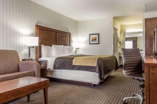a hotel room with a bed and a chair at Quality Inn Half Moon Bay-Miramar Beach in Half Moon Bay