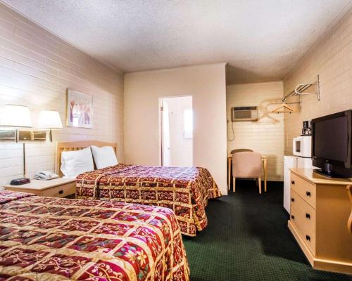 a hotel room with two beds and a flat screen tv at Jefferson Inn in Yreka