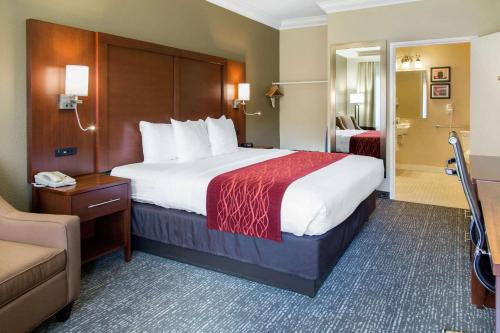a hotel room with a large bed and a chair at Comfort Inn & Suites San Francisco Airport North in South San Francisco