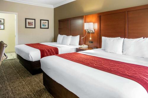 a hotel room with two beds with red sheets at Comfort Inn & Suites San Francisco Airport North in South San Francisco