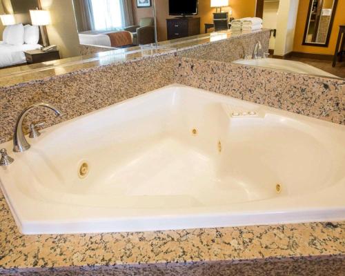 une grande baignoire dans une chambre d'hôtel dans l'établissement Comfort Suites, à Clovis