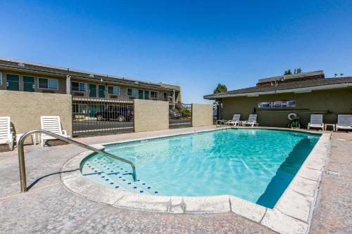 a large swimming pool with chairs and a building at Rodeway Inn Ontario Mills Mall in Guasti