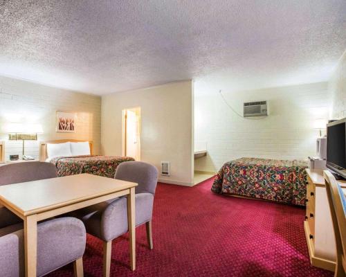 a hotel room with two beds and a table and chairs at Jefferson Inn in Yreka