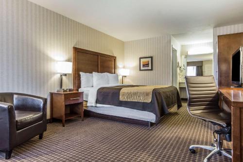 um quarto de hotel com uma cama e uma cadeira em Quality Inn Half Moon Bay-Miramar Beach em Half Moon Bay
