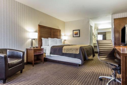 a hotel room with a bed and a chair at Quality Inn Half Moon Bay-Miramar Beach in Half Moon Bay