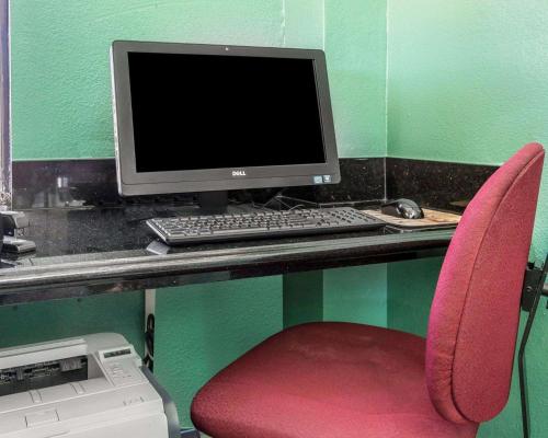 escritorio con monitor de ordenador y silla roja en Quality Inn Hemet - San Jacinto, en Hemet