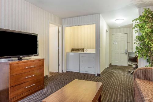 a living room with a flat screen tv on a dresser at Quality Inn Half Moon Bay-Miramar Beach in Half Moon Bay