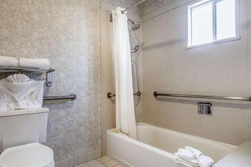 a bathroom with a toilet and a tub and a sink at Quality Inn Half Moon Bay-Miramar Beach in Half Moon Bay