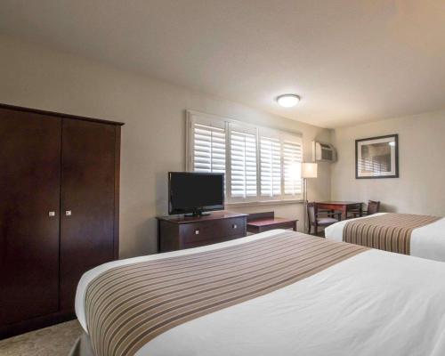 a hotel room with two beds and a flat screen tv at Rodeway Inn Convention Center in Los Angeles