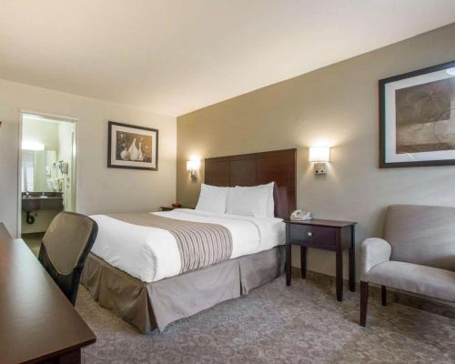 um quarto de hotel com uma cama e uma cadeira em Rodeway Inn Los Angeles Convention Center em Los Angeles