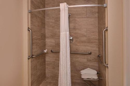 a shower with a shower curtain in a bathroom at Rancho Cordova Inn in Rancho Cordova