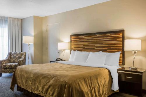 a hotel room with a large bed and a chair at Quality Inn Fallbrook I-15 in Fallbrook