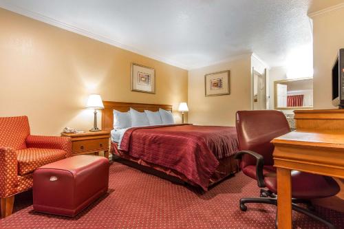 a hotel room with a bed and a desk and chair at Quality Inn & Suites Gilroy in Gilroy