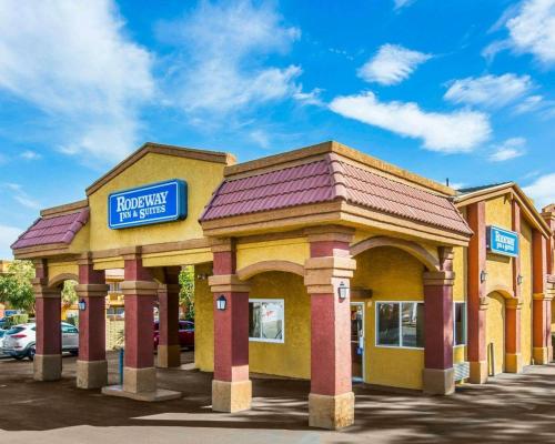 a yellow building with a sign on top of it at Rodeway Inn & Suites Corona in Corona