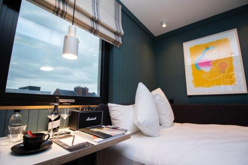 una camera d'albergo con letto e scrivania con computer portatile di The Devlin Dublin a Dublino