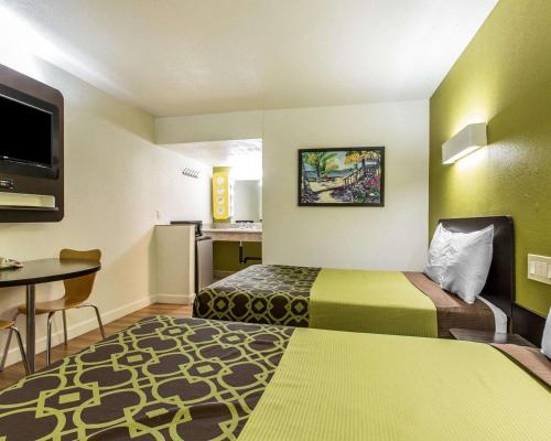 a small hotel room with two beds and a table at Rodeway Inn Downtown Hanford in Hanford