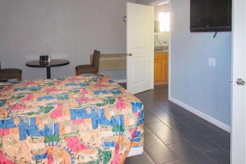 a bedroom with a bed with a colorful quilt at Rodeway Inn in San Pablo