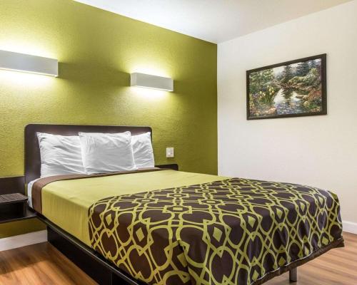a large bed in a room with green walls at Rodeway Inn Downtown Hanford in Hanford
