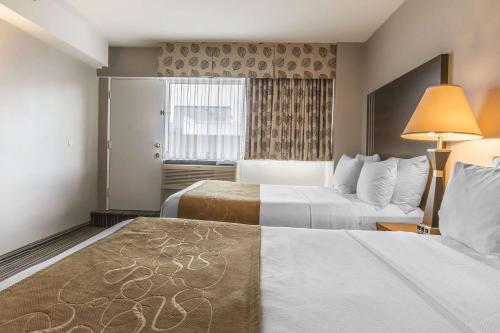 
a hotel room with a bed and two lamps at Comfort Suites Downtown in Montreal
