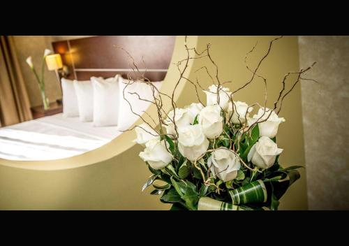 a vase of white roses in a hotel room at Quality Inn & Suites in Brossard