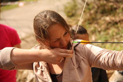 a woman aiming a bow and arrow in a field at Hotel U Kabinky in Janske Lazne
