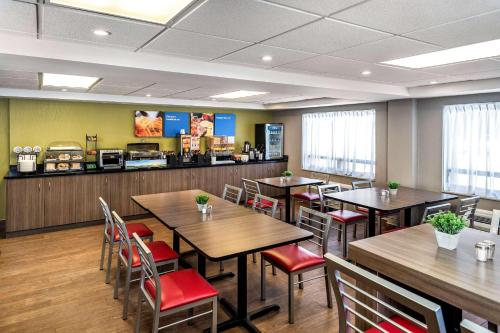 a restaurant with wooden tables and red chairs at Comfort Inn in Brandon