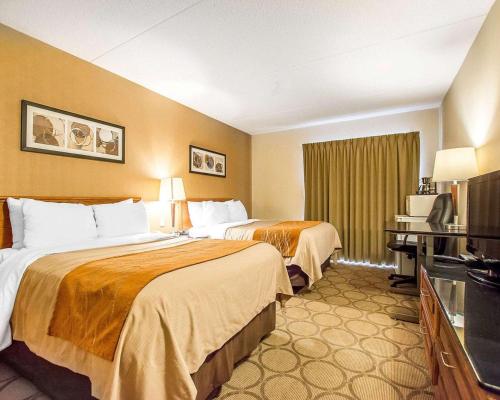 a hotel room with two beds and a television at Comfort Inn Kirkland Lake in Kirkland Lake