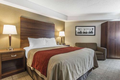 a hotel room with a bed and a chair at Comfort Inn in Huntsville