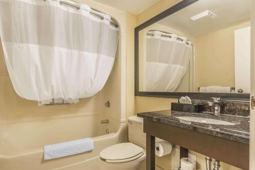 a bathroom with a sink and a toilet and a mirror at Comfort Inn Cobourg in Cobourg