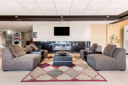 a living room with two couches and a tv at Comfort Inn Airport West in Mississauga