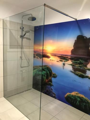 a shower stall with a painting of a sunset at Langleys Port Campbell Hobby Farm in Port Campbell
