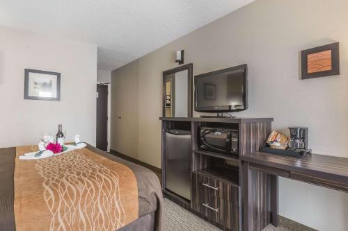 a hotel room with a bed and a flat screen tv at Comfort Inn Trenton in Trenton