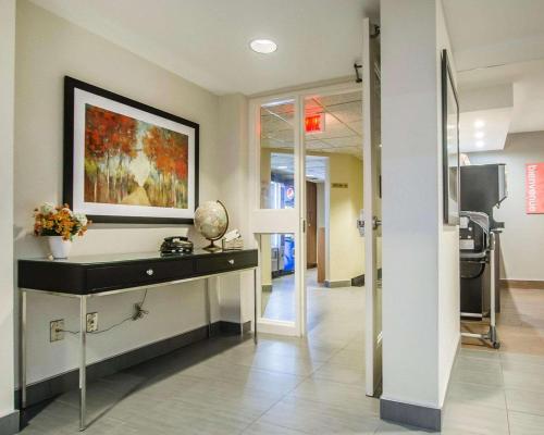 a hallway with a desk and a painting on the wall at Comfort Inn Rimouski in Rimouski