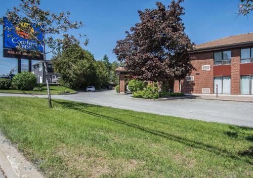 a sign in the grass in front of a building at Comfort Inn Sherbrooke in Sherbrooke