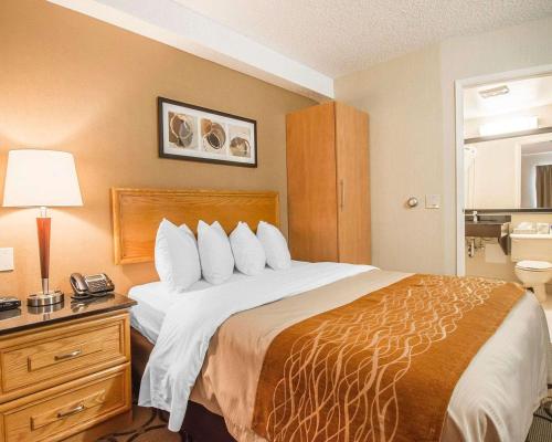 a hotel room with a large bed with a telephone at Comfort Inn in Rimouski