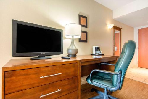 a room with a desk with a television and a chair at Comfort Inn & Suites Shawinigan in Shawinigan