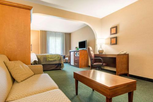 a hotel room with a couch and a desk and a bed at Comfort Inn & Suites Shawinigan in Shawinigan