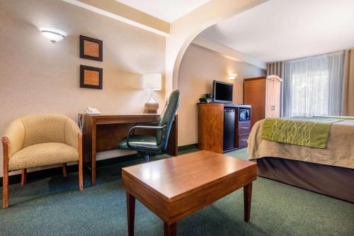 a hotel room with a bed a desk and a chair at Comfort Inn & Suites Shawinigan in Shawinigan