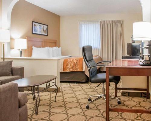 a hotel room with a bed and a desk at Comfort Inn Winnipeg South in Winnipeg