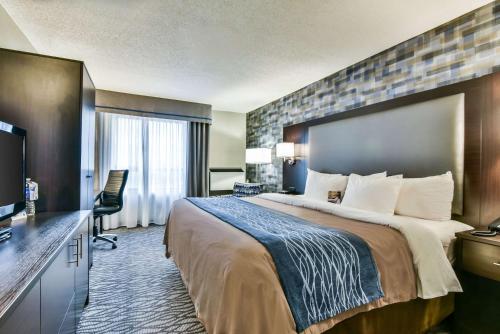 Pokój hotelowy z dużym łóżkiem i telewizorem w obiekcie Comfort Hotel Airport North w mieście Toronto