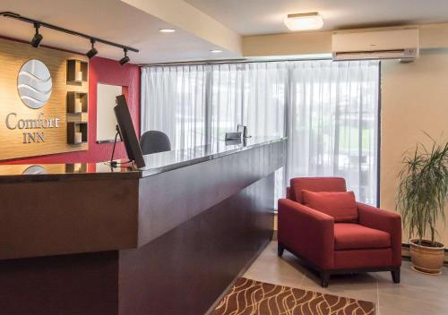 an office with a reception desk and a red chair at Comfort Inn Sherbrooke in Sherbrooke