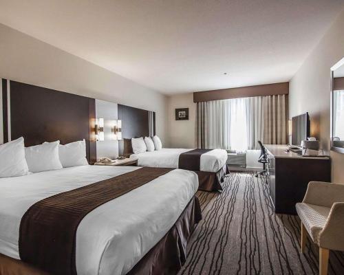 a hotel room with two beds and a television at Comfort Hotel Vancouver Airport in Richmond