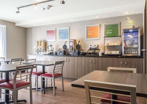 a restaurant with tables and chairs and a counter at Comfort Inn Sherbrooke in Sherbrooke