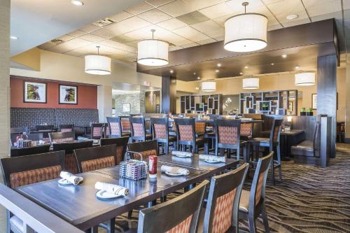 un comedor con mesas y sillas en un restaurante en Quality Hotel & Conference Centre, en Fort McMurray