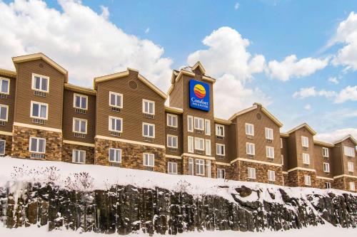 a building with a sign on it in the snow at Comfort Inn & Suites in Saint-Jérôme
